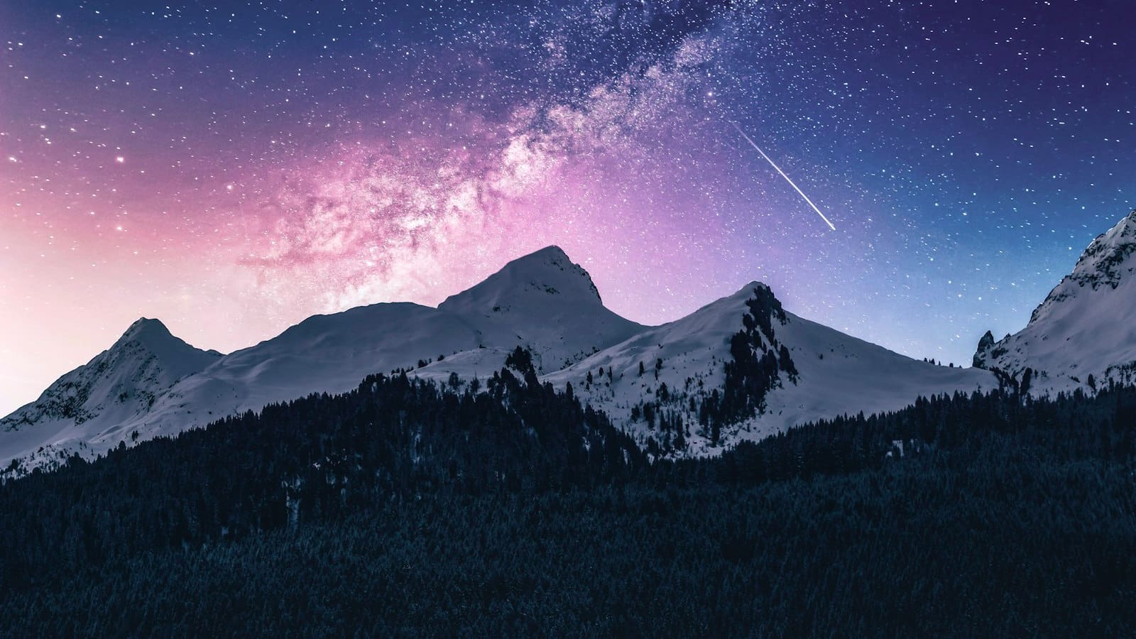 The Milky Way and a shooting star over dark mountain ridgelines at night