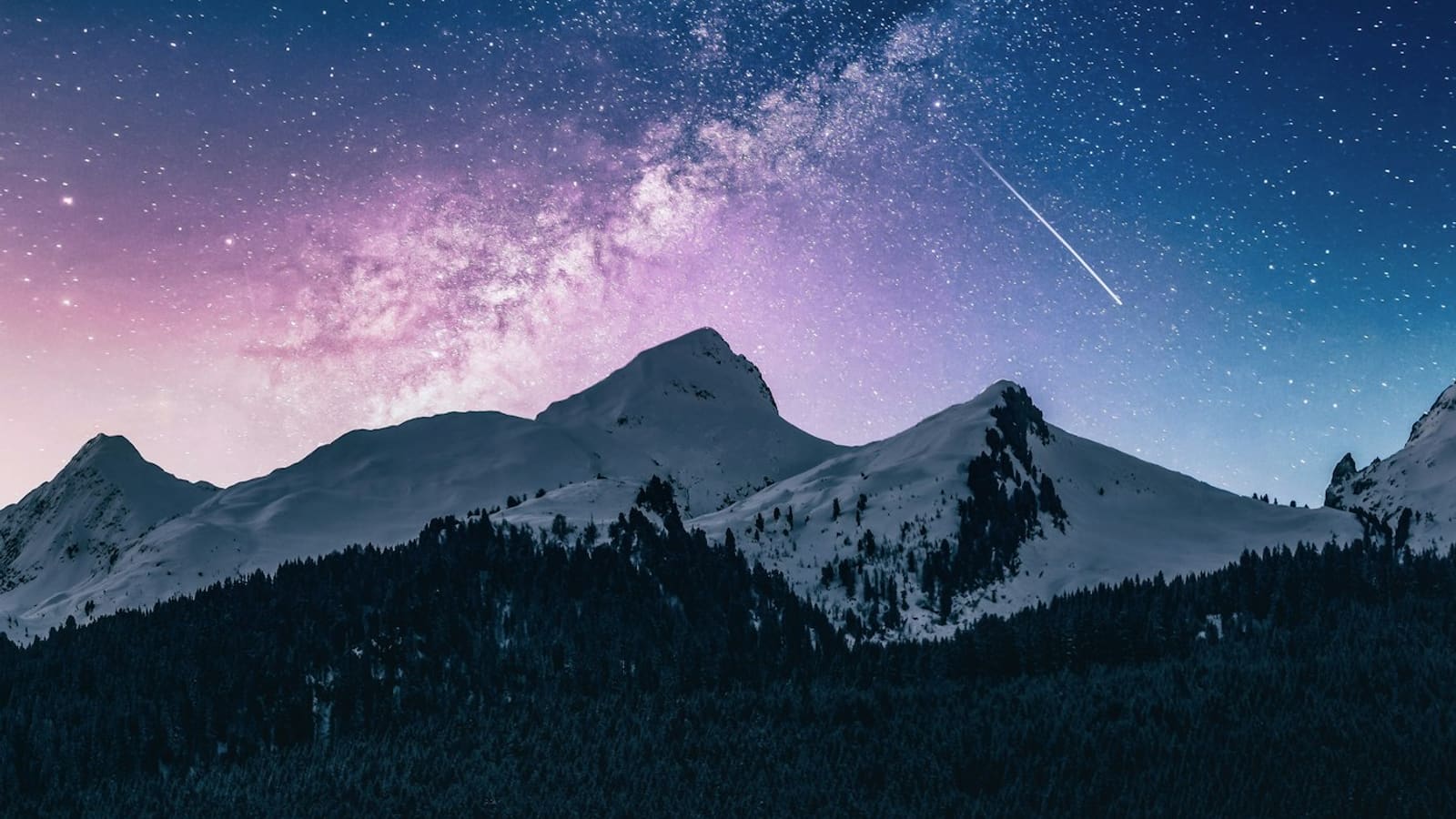 The Milky Way and a shooting star over dark mountain ridgelines at night